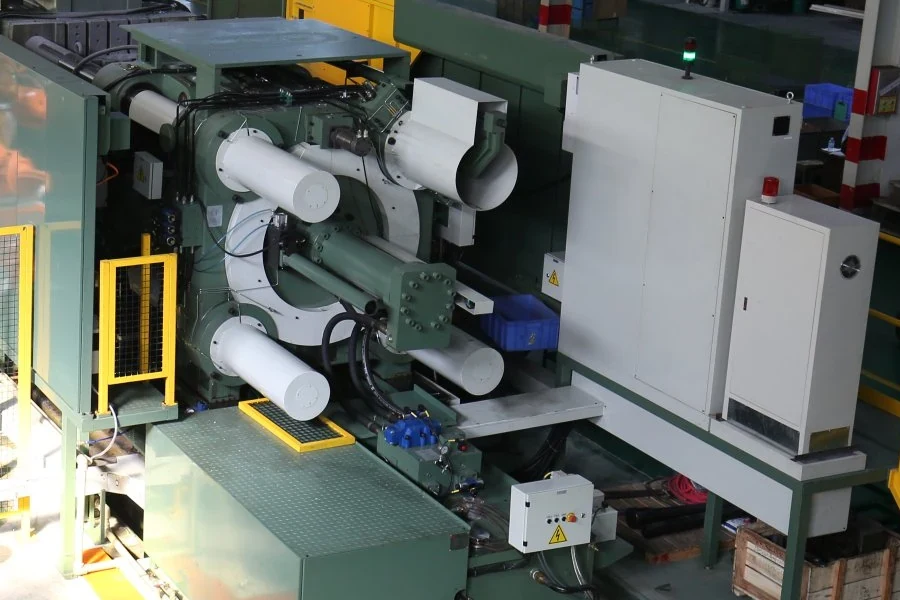 Close view of the green die-casting machine and attached control cabinets