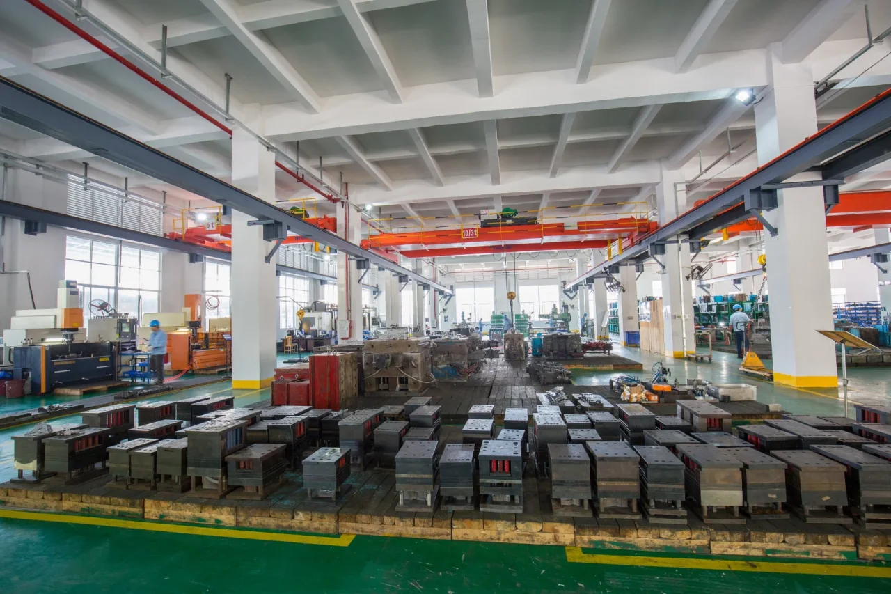 Mold blocks arranged on the toolroom floor beneath overhead cranes