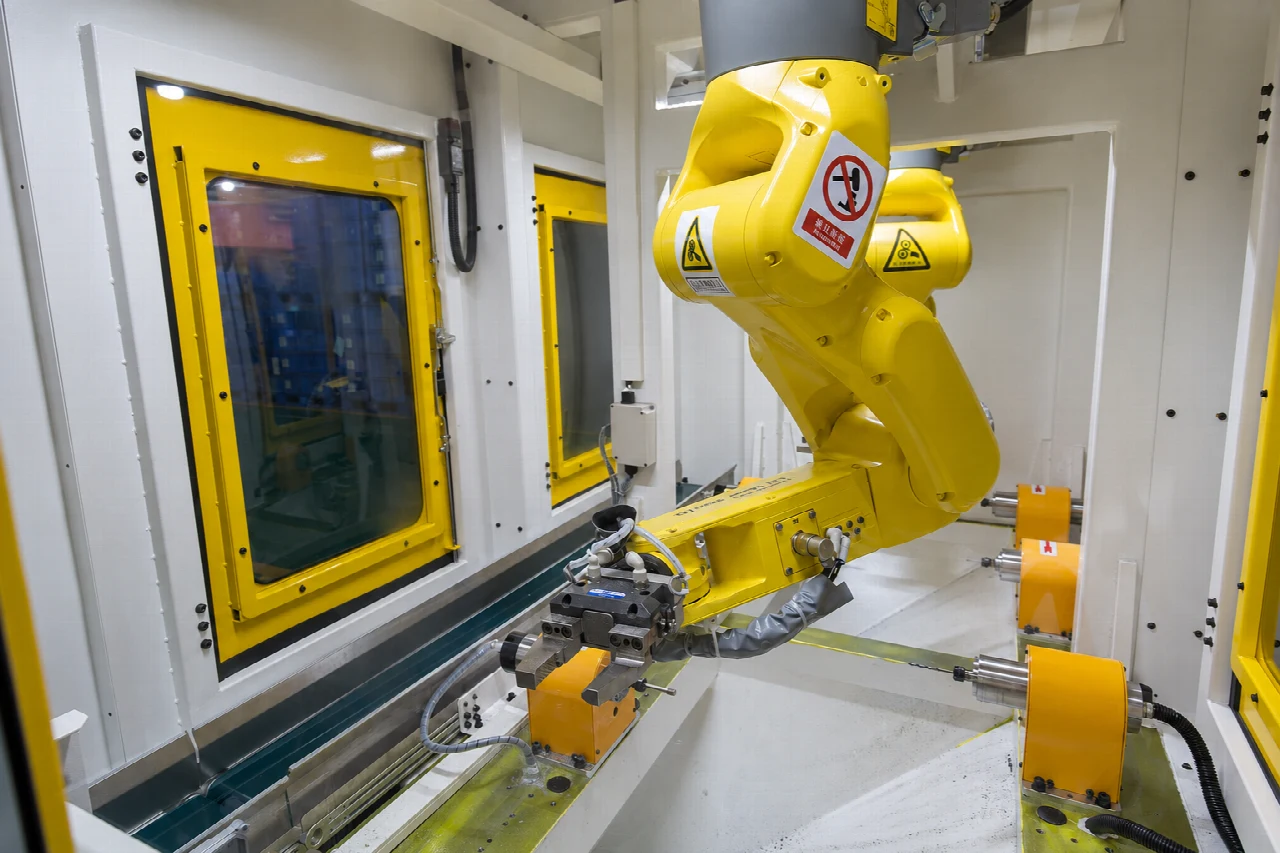 Yellow industrial robot in an enclosed production cell